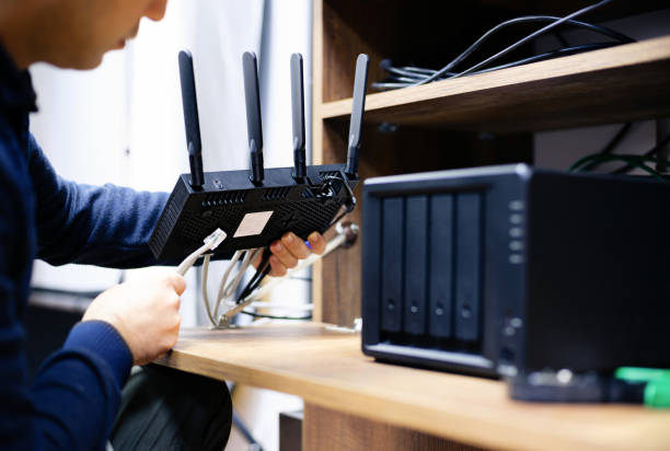 Homeowner setting up a modern Wi-Fi router for internet in a new house quickly
