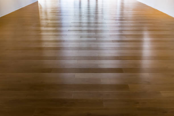 A spotless and gleaming hardwood floor reflecting natural light in a well-lit room.